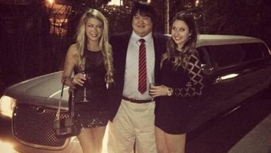Zhong pictured with two women in front of a limousine.